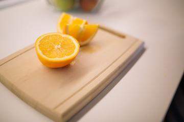 Fresh orange on a wooden cutting board.
