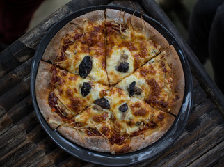 Vegetarian pizza with mushrooms on a wooden table