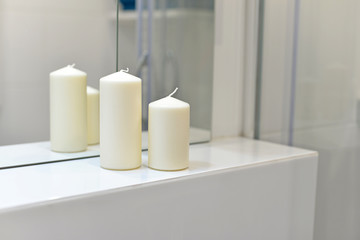 Białe świece odbijające się w lustrze