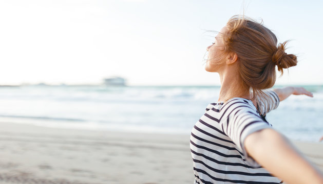 happy woman enjoying freedom with open hands on sea