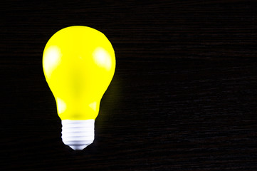 yellow light bulb as a symbol of idea on a dark background