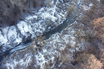 Aerial view on frozrn river in forest landscape in winter season