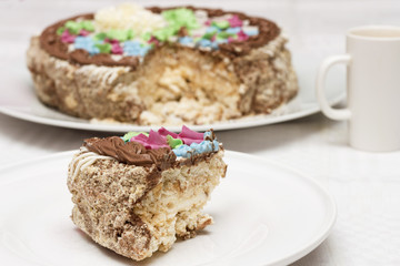 Cake with cream, nuts and meringue with cup of coffee