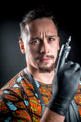 Master of the art of tattooing with a tattoo gun in tattoo studio