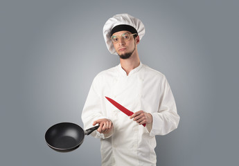 Cook with kitchen tools and empty wallpaper