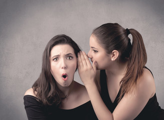 girl telling secret things to her girlfriend