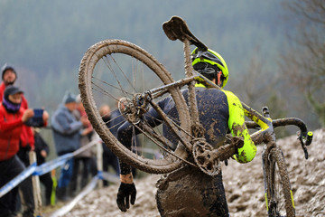 ciclocross competición ciclista con la bicicleta al hombro en pista de barro país vasco...