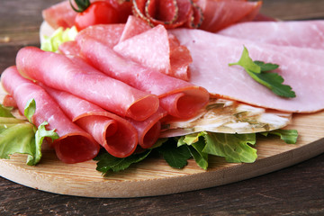 Food tray with delicious salami, pieces of sliced ham, sausage, tomatoes, salad and vegetable - Meat platter with selection