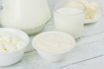Different dairy products, white wooden background