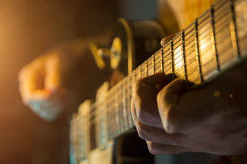 Musician man is playing the guitar on the concert