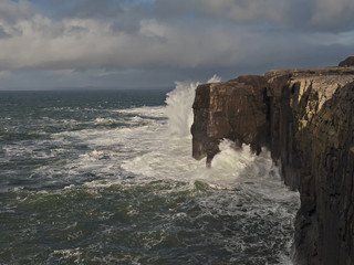 Fototapeta premium Ocean wave hits Mini cliffs, county Clare, Ireland.
