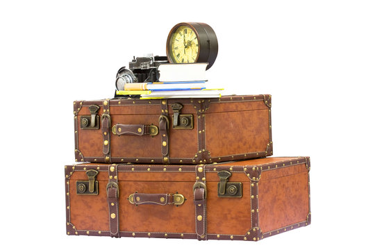 Travel concept - vintage traveling items - suitcases, clock, camera and books, isolated on white background
