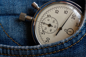 Vintage antiques Stopwatch, in old worn dark blue denim pocket, value measure time, old clock arrow minute, second accuracy timer record