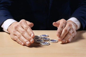 Man with silver bitcoins sitting at table