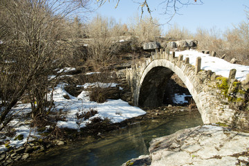 Arkoudas bridge old in Ioannina Zagori Greeece snow ice winter time