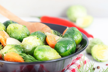 Homemade cooked Brussel Sprouts with salt, pepper and onions in black bowl 