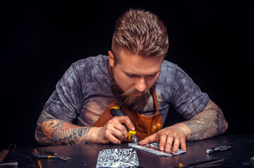Leather master works with leatherwork in his work area