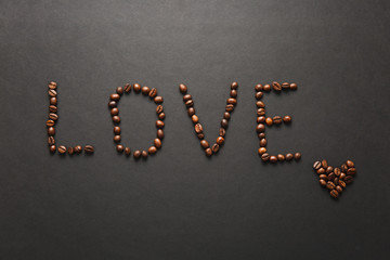 Top view of letter love, word made from coffee beans on black background for design. Saint Valentine's Day card on fabruary 14, holiday concept. Copy space for advertisement.