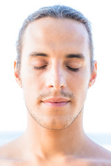 Portrait of sexy bare-chested man with closed eyes, nose ring and hair tied back
