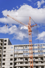 Fototapeta na wymiar Crane and building construction site against blue sky