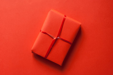 Gift on St. Valentine's Day in red wrapping paper on a red background. Flat lay. 