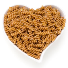Uncooked wholemeal pasta isolated white background.