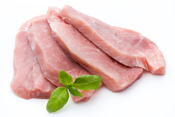 Fresh pork fillet with basil on a white background.