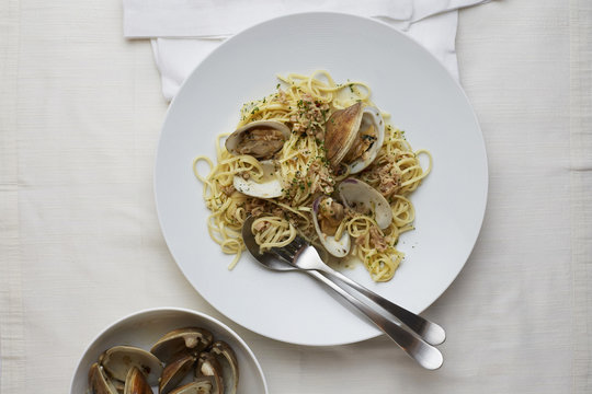 Linguine with Clams in a bowl with a white Linen surface.