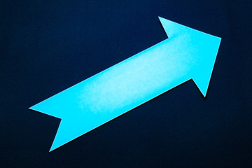 Blue paper right arrow on dark blue background.