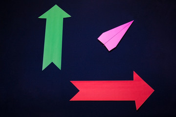 Business concept with paper plane and colored arrows on dark blue background