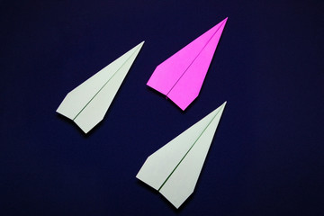 colored paper plane on a dark blue background. Teamwork concept