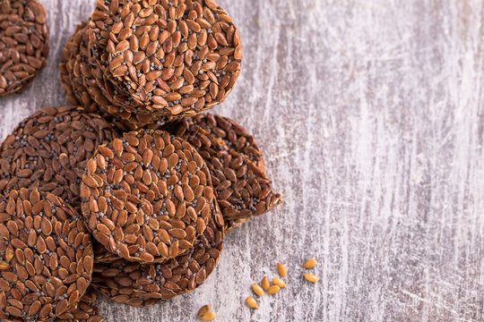 Flax seeds crackers on wooden background with copy space