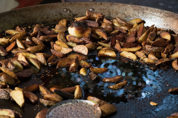 Fried potatoes on a huge frying pan, fast food.