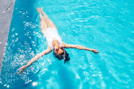 Woman relax in swim pool. Luxury resort vacation