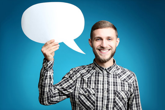 Young Man Holding Speech Bubble On Blue Background