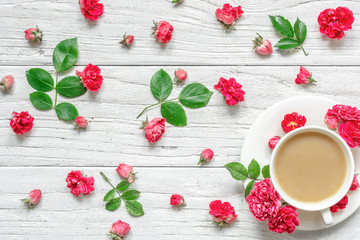 cup of cappuccino or coffee with milk with flowers composition made of pink rose flowers