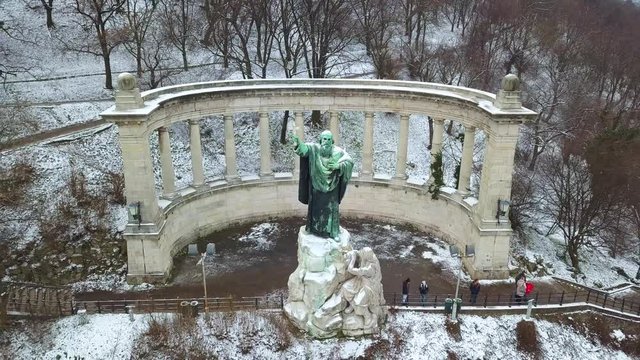 Budapest, Hungary - Aerial footage of drone flying away from the St.Gellert Bishop statue and memorial on a winter day with snowy Gellert Hill at background