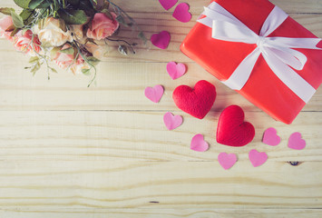 Naklejka na ściany i meble Gift box white bow ribbon and heart with flower on wood table background top view, february of valentine's day in concept.