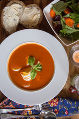 Tomato Bisque with Boiled Egg and Basil Garnish. High angle View.