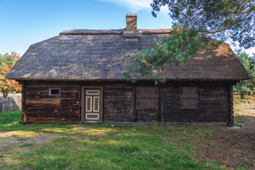 Obraz premium Old wooden thatched roof house in heritage park of Kampinos Forest in Poland