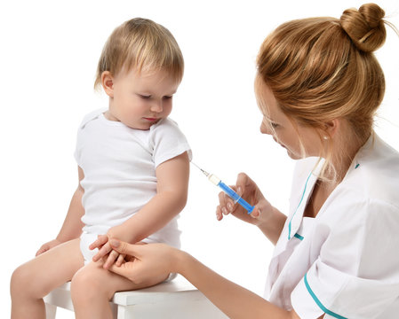 Doctors hand with syringe vaccinating child baby flu injection shot