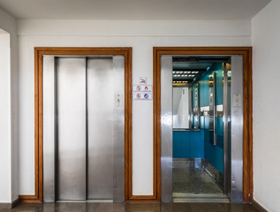 Open and closed chrome metal hotel building elevator doors realistic photo. © Lillian