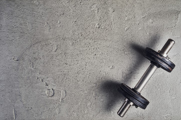 Fitness or bodybuilding concept background. Product photograph of old iron dumbbells on grey, conrete floor in the gym. Photograph taken from above, top view with lots of copy space