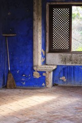 Abandoned broom and Colorful texture in an old blue painted wall