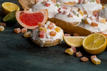 Homemade gingerbread cookies with fruits and icing glaze on wooden dark table.