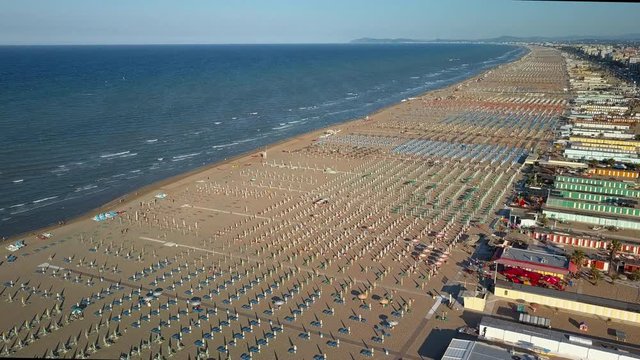 The wide coastal beach in Rimini Italy where lots of beach chairs umbrellas and establishments on the coast area