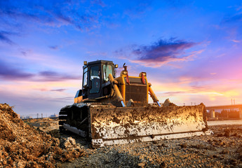 bulldozer at construction site and sunrise landscape - obrazy, fototapety, plakaty