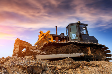bulldozer at construction site and sunrise landscape