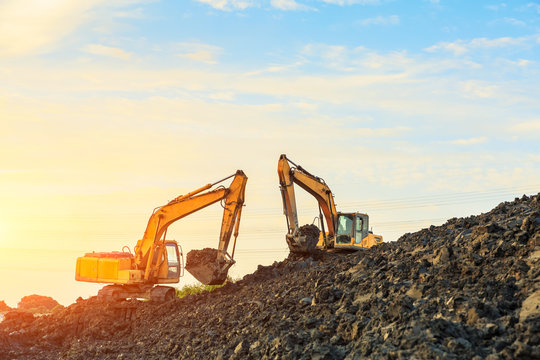 excavator working on construction site and sunrise landscape