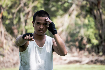 A Boxer practices his boxing step in a park.